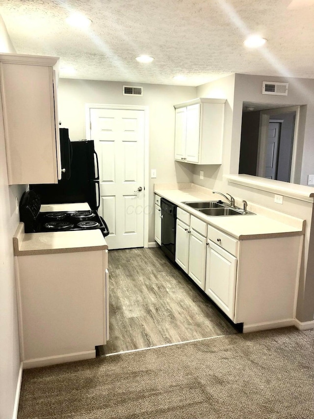 kitchen featuring visible vents, a sink, a textured ceiling, light countertops, and dishwasher