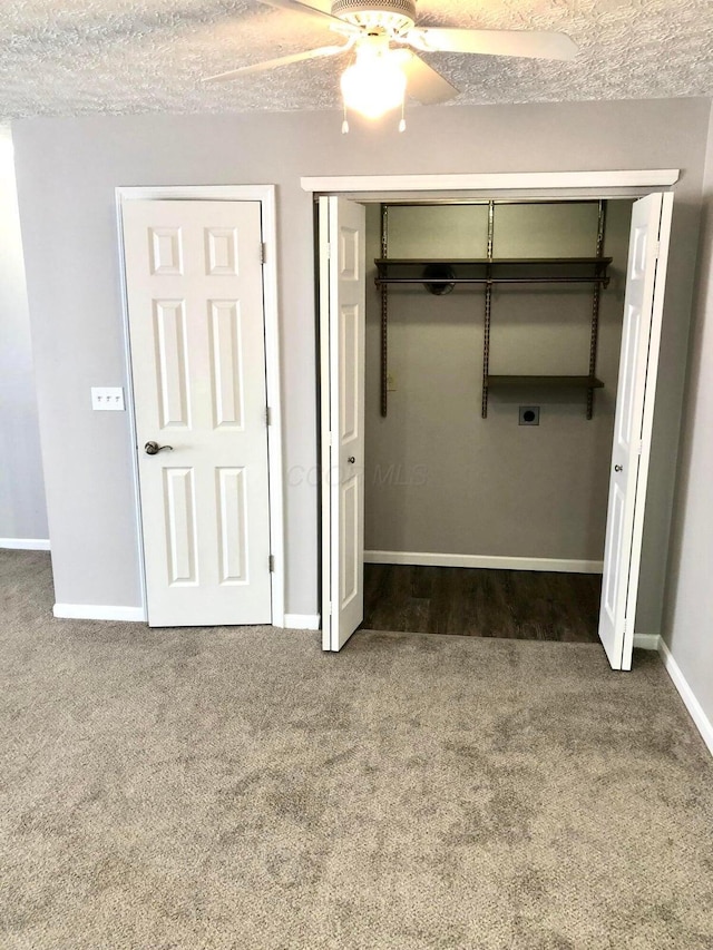 unfurnished bedroom with a closet, baseboards, a textured ceiling, and carpet flooring