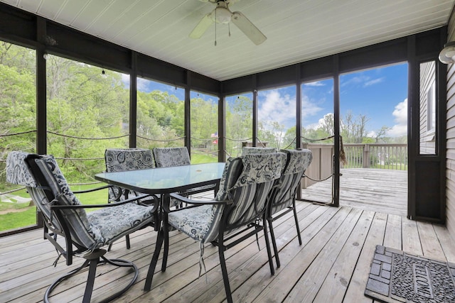 sunroom / solarium with a ceiling fan and outdoor dining space