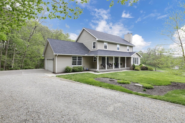 view of front of house with covered porch, driveway, a chimney, a garage, and a front lawn