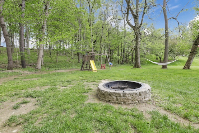view of yard featuring a playground and an outdoor fire pit