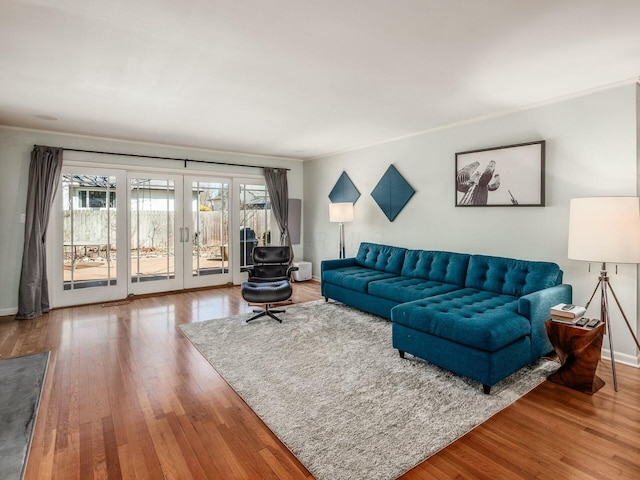 living area with french doors, baseboards, and wood finished floors