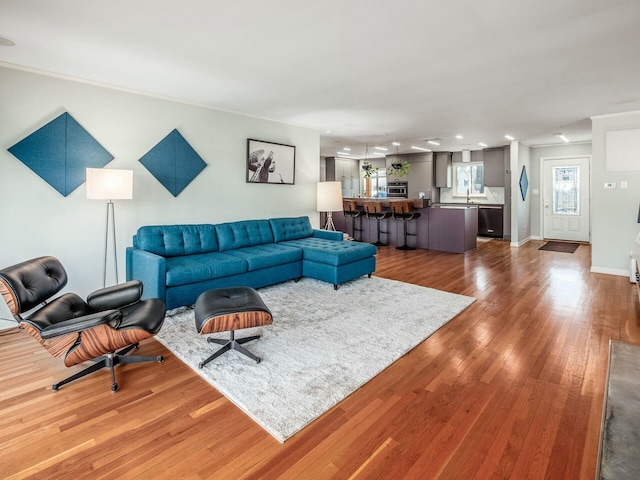 living area with recessed lighting, wood finished floors, and baseboards