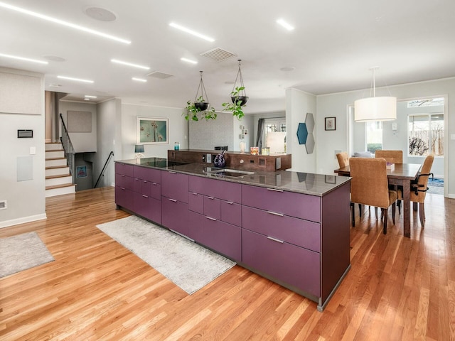 kitchen featuring a kitchen island, visible vents, modern cabinets, and light wood-style floors