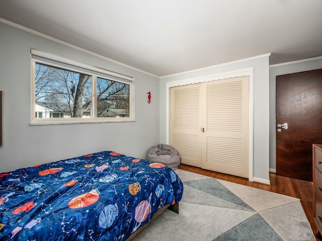 bedroom with a closet, wood finished floors, and crown molding