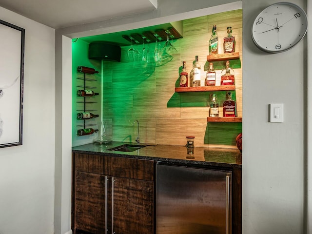 bar featuring indoor wet bar, refrigerator, and a sink