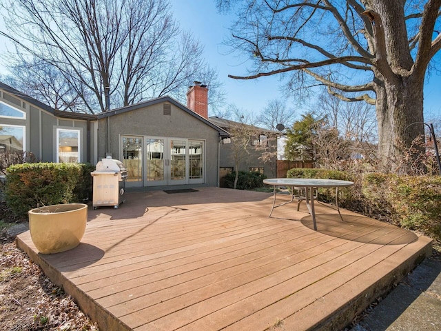 wooden terrace with french doors and area for grilling