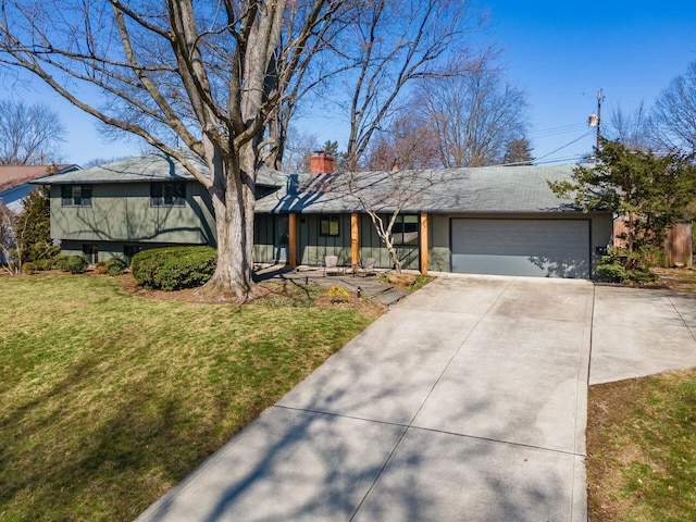 view of front facade with an attached garage, a chimney, driveway, and a front yard