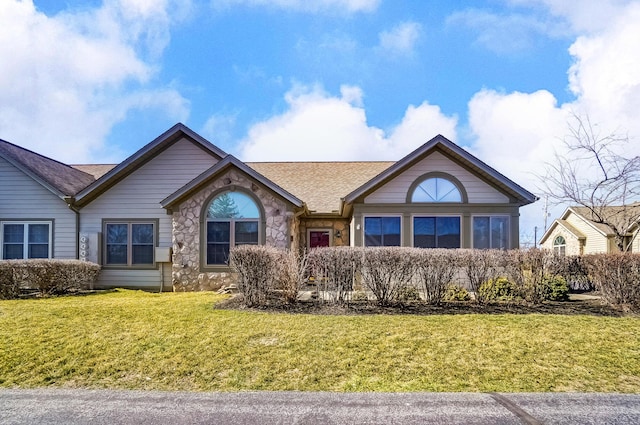 single story home featuring stone siding and a front yard