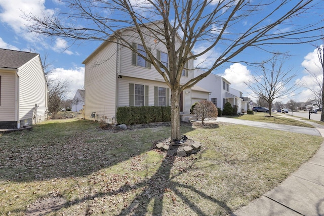 view of front of property featuring a front yard, concrete driveway, and an attached garage