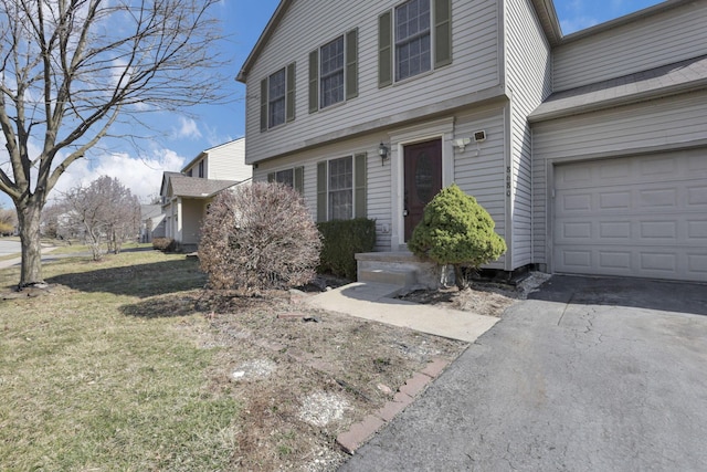 view of front of home with aphalt driveway, a garage, and a front yard