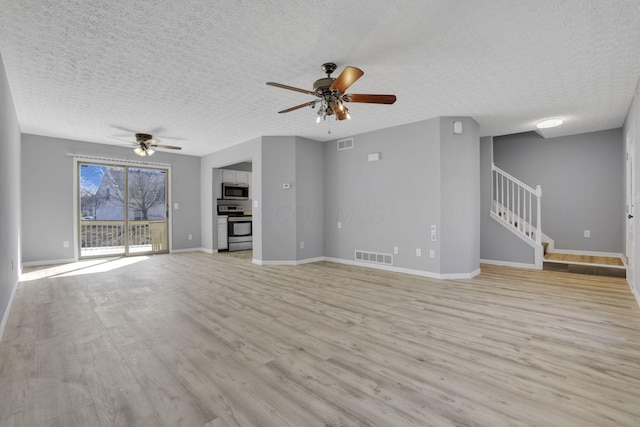 unfurnished living room featuring visible vents, light wood-style flooring, stairway, and ceiling fan