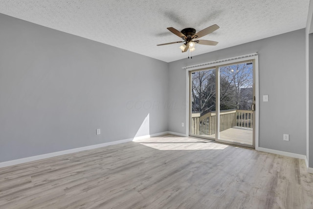 empty room featuring baseboards, a textured ceiling, wood finished floors, and a ceiling fan