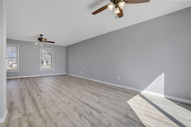 unfurnished room featuring wood finished floors, baseboards, and a textured ceiling