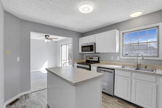 kitchen with white cabinets, visible vents, appliances with stainless steel finishes, and a sink