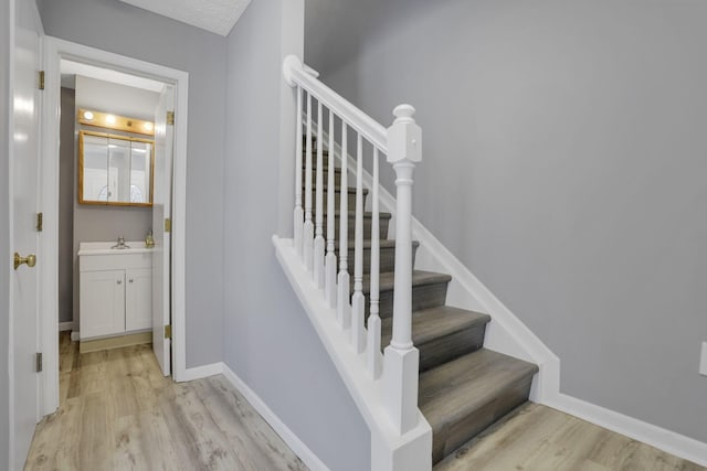 stairs with wood finished floors and baseboards