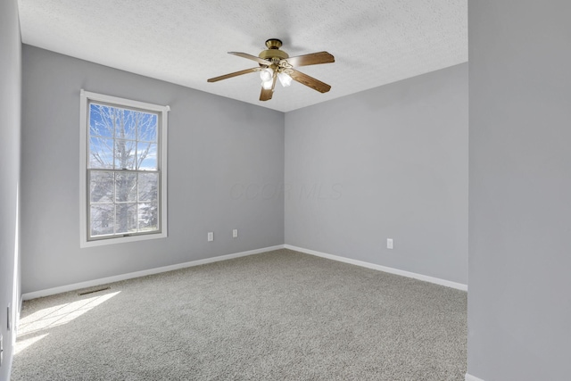 unfurnished room featuring carpet flooring, a ceiling fan, baseboards, and a textured ceiling