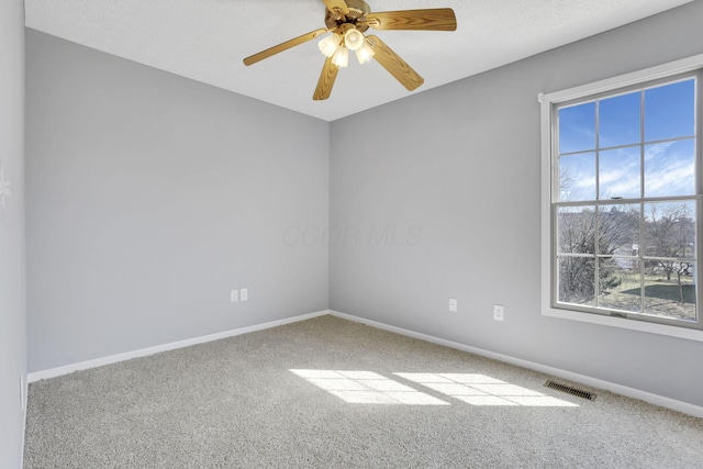 unfurnished room featuring visible vents, carpet flooring, a ceiling fan, and baseboards