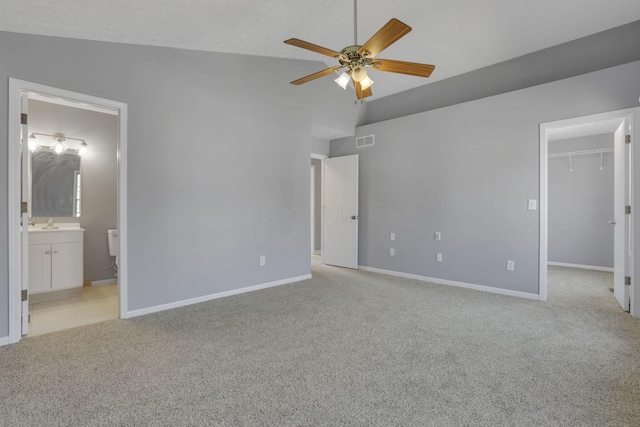 unfurnished bedroom with visible vents, light carpet, ensuite bathroom, baseboards, and a spacious closet