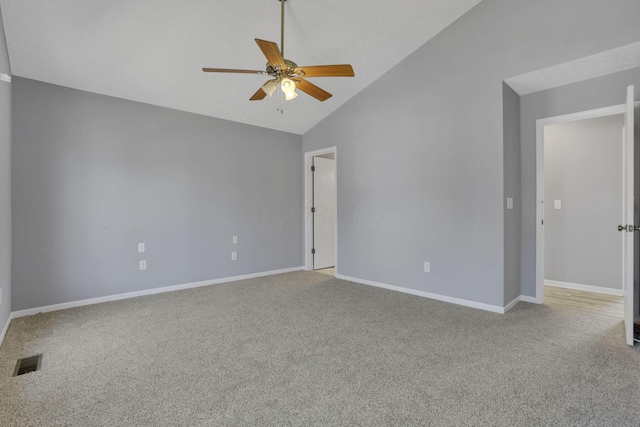 carpeted spare room with visible vents, baseboards, ceiling fan, and high vaulted ceiling