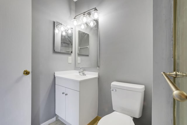 bathroom with vanity, toilet, and baseboards