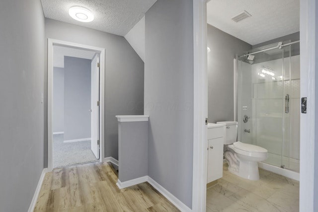 full bathroom with baseboards, toilet, vanity, a stall shower, and a textured ceiling