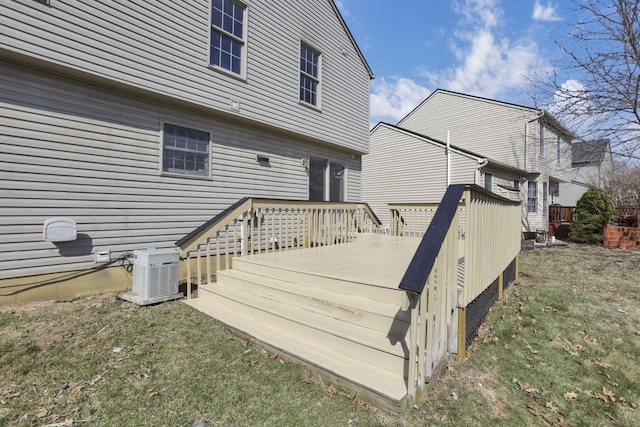 wooden deck with central air condition unit and a lawn