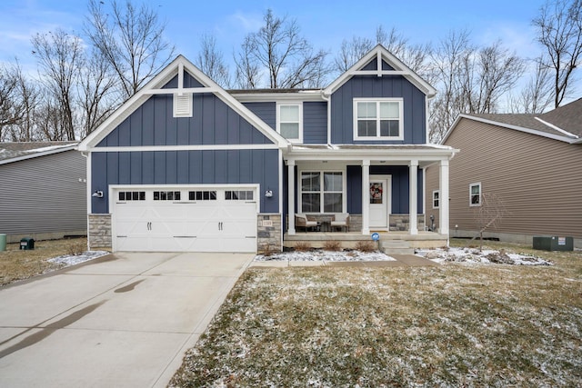 view of front of house with a porch, an attached garage, board and batten siding, and stone siding