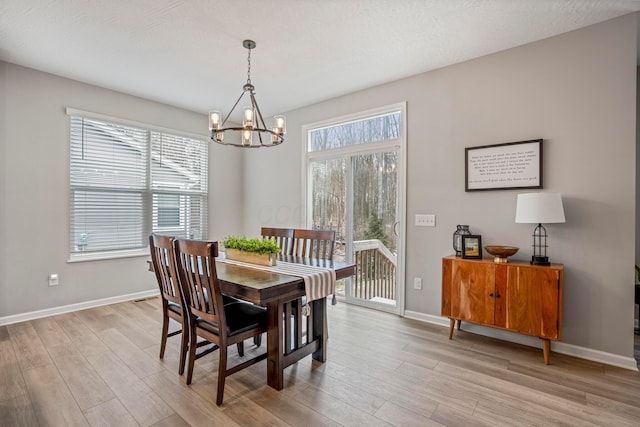 dining space with light wood-style flooring, a healthy amount of sunlight, and baseboards