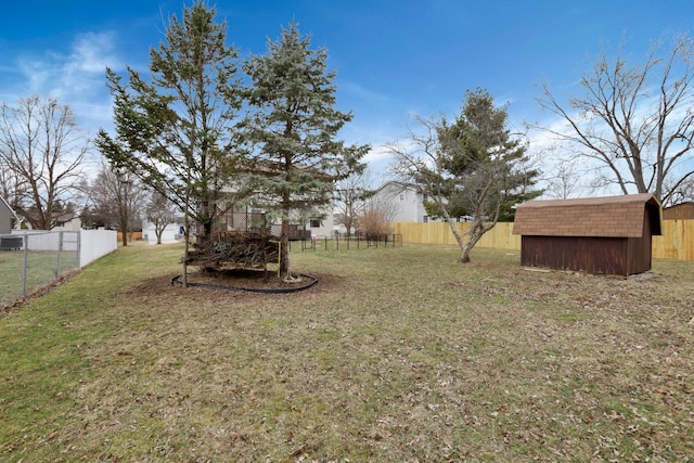 view of yard featuring a fenced backyard, a storage unit, and an outdoor structure