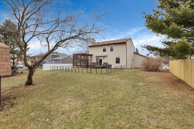 rear view of property featuring a lawn and a fenced backyard