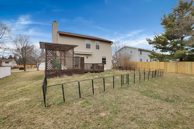 rear view of house with a deck, fence, a lawn, a pergola, and a chimney