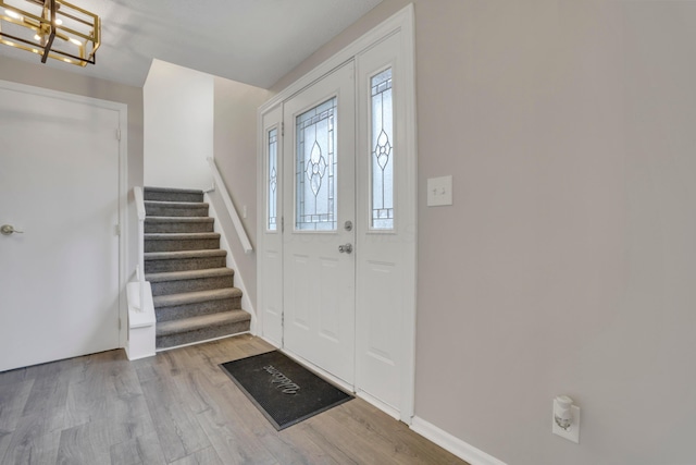 entryway featuring stairway, wood finished floors, and baseboards