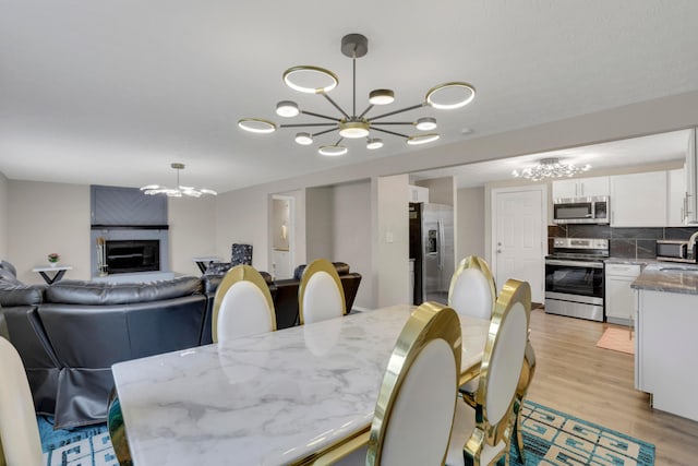 dining space with a chandelier and light wood-type flooring