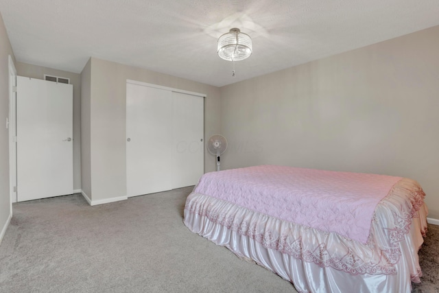 carpeted bedroom featuring a ceiling fan, visible vents, and a closet