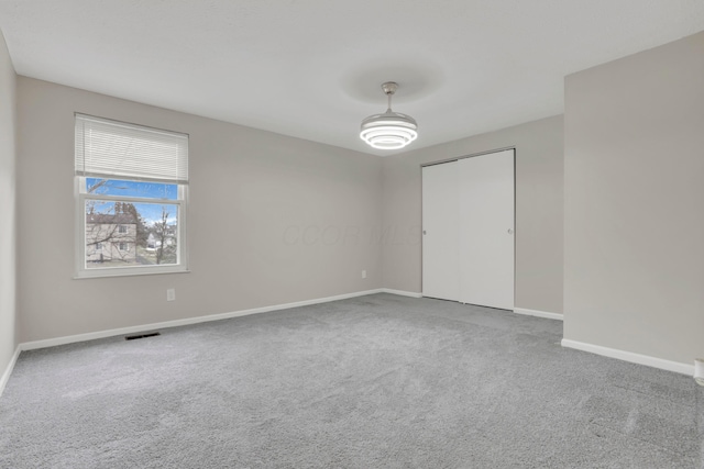 interior space featuring carpet floors, visible vents, and baseboards