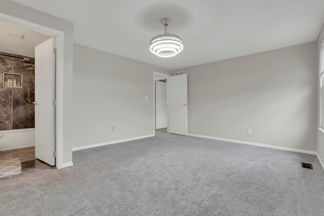 unfurnished bedroom with carpet, visible vents, and baseboards