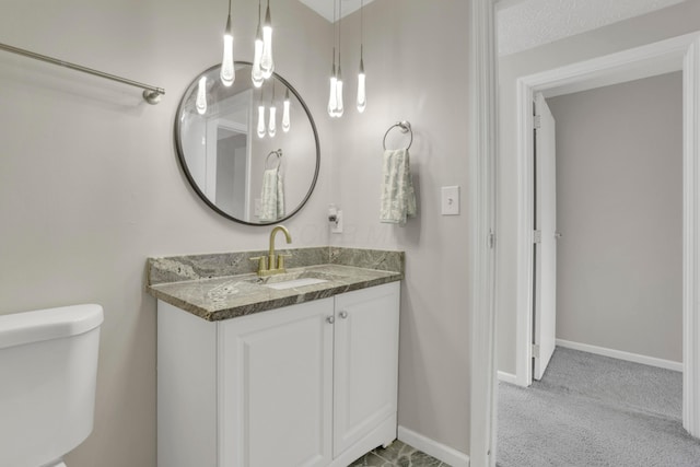 bathroom with toilet, baseboards, and vanity