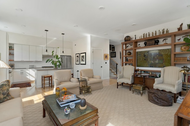 living room featuring light wood-style floors and stairs