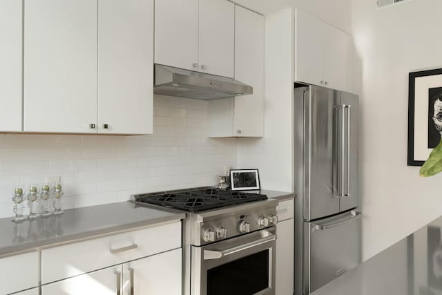 kitchen featuring stainless steel appliances, backsplash, white cabinets, and under cabinet range hood