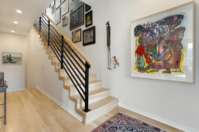 stairs with recessed lighting, baseboards, and wood finished floors