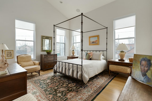 bedroom featuring high vaulted ceiling and light wood-style flooring