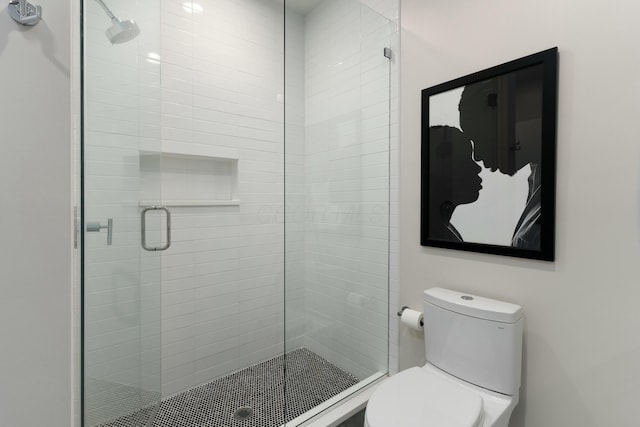 bathroom featuring toilet and a shower stall