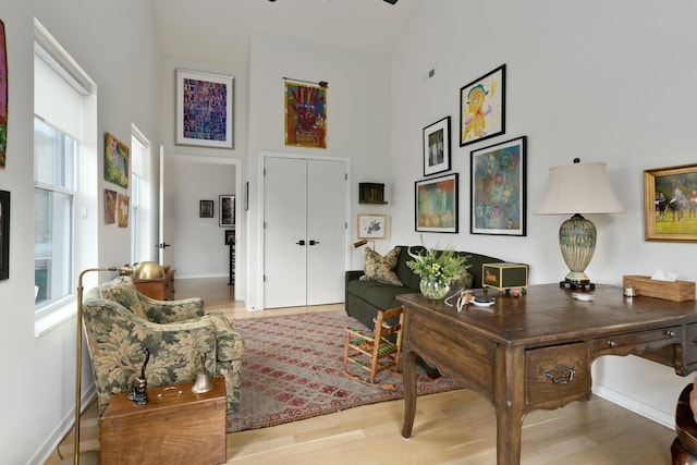 office area with a high ceiling, wood finished floors, and baseboards