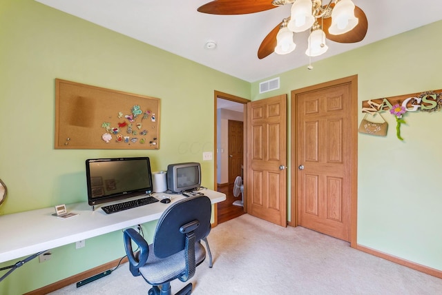 office space featuring light carpet, baseboards, visible vents, and a ceiling fan