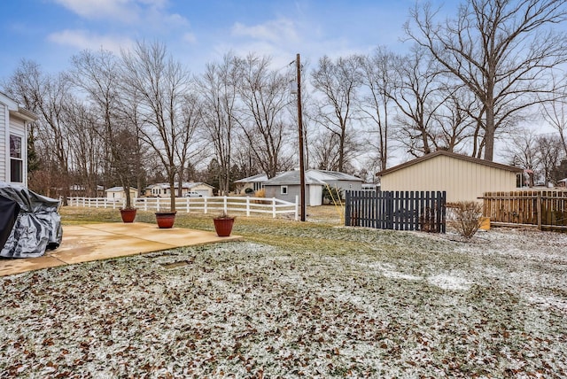 view of yard featuring a patio area, fence, and an outdoor structure