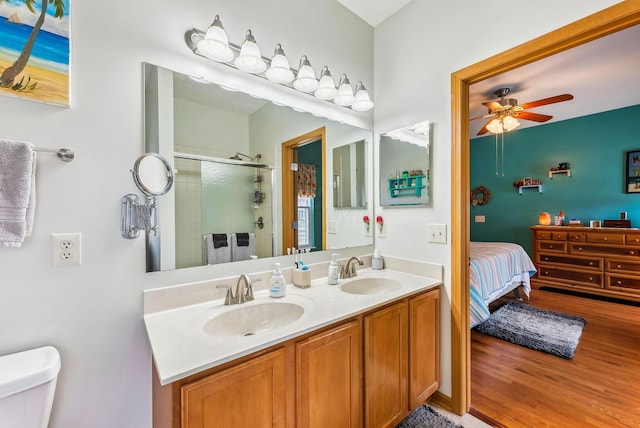 bathroom with a sink, a shower stall, toilet, and double vanity