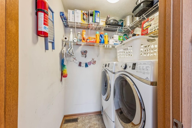 washroom with baseboards, laundry area, visible vents, and washer and dryer