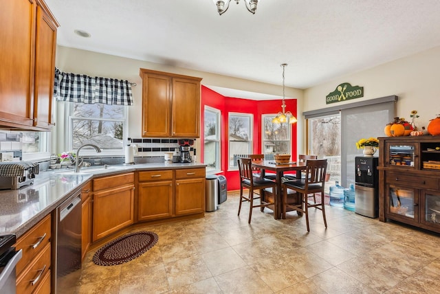 kitchen featuring decorative backsplash, brown cabinetry, stainless steel dishwasher, pendant lighting, and a sink