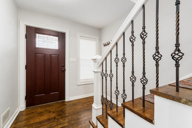 foyer entrance featuring stairs, dark wood-style flooring, visible vents, and baseboards